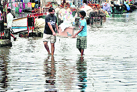 Devotees carry an idol of lord Ganesha on a waterlogged road ahead of Ganesh Chaturthi in Ludhiana on Tuesday.
