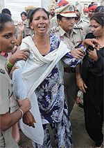 Lady cops take away a woman accused of encroaching upon the road in Gopal Nagar area of the city on Wednesday