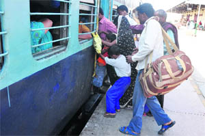 Passengers scramble for boarding a train