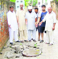 Residents show a dislocated portion of interlocking tiles at Ahata Sujapuria in Jagraon.