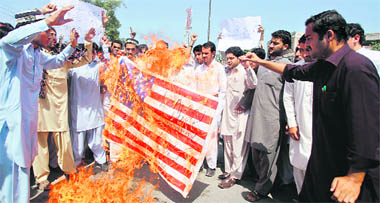 Students burn an American flag during an anti-US rally in Peshawar on Wednesday