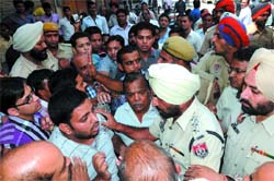Enraged traders argue with DSP Gurmeet Singh after BJP workers allegedly slapped a businessman while enforcing the bandh.