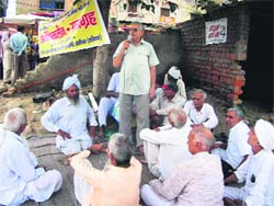 Activists of the Railway Overbridge Sudhar and Nirman Sangharsh Samiti stage a protest at a level crossing in Sonepat. 