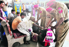 Policemen search bags of passengers at the railway station in Ludhiana on Thursday. Tribune photo: Himanshu Mahajan