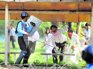 A policeman clashes with protesters near the US Embassy in Islamabad on Thursday. 