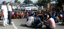 Students and their parents block the Fazilka-Ferozepur highway to press for the appointment of teachers in Government Primary School at village Lal Singh Jhuge in Fazilka district. Photo: Praful Chander Nagpal