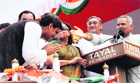 Former state minister Matbar Singh Kandari, who joined the Congress, gives blessings to Saket Bahuguna at a public rally in Dehradun on Friday.