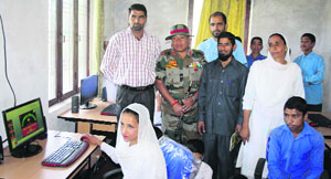 Army personnel along with school officials pose with new computers at Government Middle School, Bisali.