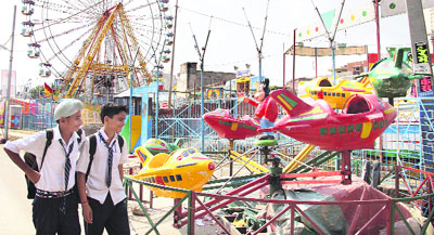 School students have a look at the rides being set up for Baba Sodal Fair in Jalandhar