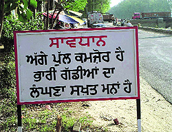 A board shows prohibiton against crossing the bridge.