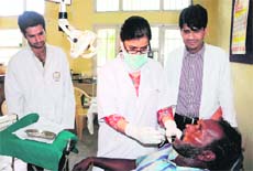 A doctor examines a patient during the free dental checkup camp at Satellite Hospital at Ranjit Avenue in Amritsar on Saturday. 