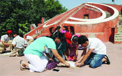 Schoolchildren conduct an experiment to measure the circumference of Earth under the guidance of the Science Popularisation Association of Communicators and Educators at Jantar Mantar in New Delhi on Saturday. Tribune photo: Mukesh Aggarwal