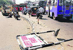 A traffic board installed at the busy Bikram Chowk lies on the ground in Jammu on Saturday