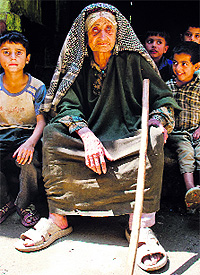 An elderly woman poses with children for a photograph in Bandipora