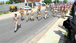 Police personnel run towards protesting members of the Sarv Shiksha Abhiyan and Rashtriya Madhyamik Shiksha Abhiyan Non-Teaching Employees' Union on GT Road in Ludhiana on Saturday.