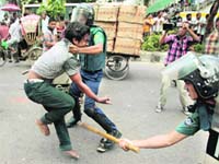 Bangladeshi policemen detain an activist of an Islamic group during a protest in Dhaka on Saturday
