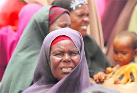 An internally displaced woman waits for food aid at a centre in Ubeyd camp in Mogadishu