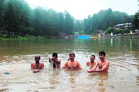 Devotees take a bath in the Dal Lake on the occasion of Radhashtami at Naddi near McLeodganj on Sunday