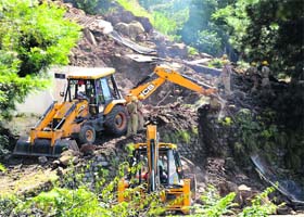 A JCB machine being used to clear debris that fell on two buildings at Barog