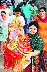 A devotee carries an idol of Lord Ganesha for immersing it in the Tawi on Sunday