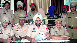 Police officials present the murder accused before the media in Jalandhar on Sunday. They also show a pistol seized from another youth