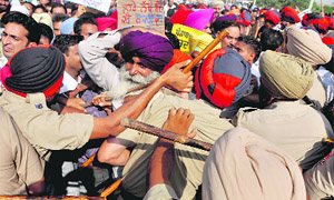 Policemen try to stop the protesters in Ludhiana. 