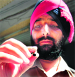 A policeman shows an empty bullet shell recovered from the spot.