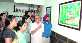 Artists look at a painting of Deepti Kanda at an exhibition at KT Kala in Amritsar on Monday.