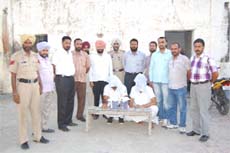 Policemen with the two accused who were caught with illegal weapons and cartridges near the district courts during a checking on Monday. 