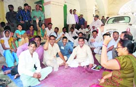 Striking sanitary workers of the DMC sit on a dharna in Dehradun on Monday