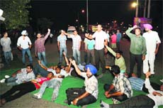 Unemployed teachers block a highway in Ludhiana on Sunday night; and (below) police officials try to persuade them to lift their dharna. 