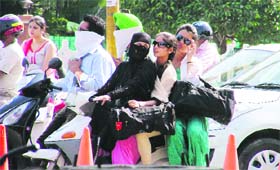 Girls triple ride a scooter in Ludhiana on Monday.