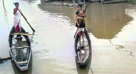 People use boats to move to safer places in flood-hit Sivasagar district of Assam on Monday.