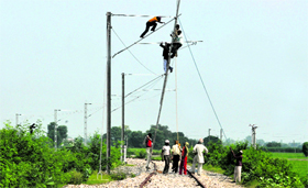 Railway officials engaged in electrification work near Khumano.