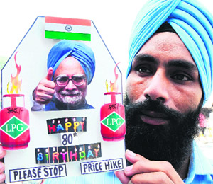 Artist Gurpreet Singh shows a greeting card made for the Prime Minister Manmohan Singhs 80th birthday with a message to stop price hike pasted on it, in Amritsar on Tuesday.