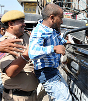 An accused being bundled into a police van; Civil Lines SHO Gurdev Bhalla speaks to the bystanders