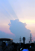 The sky over the city turns golden with the setting sun casting a brilliant hue over it