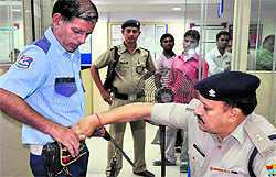 Haridwar SP Kiran Lal Shah inspects a bank security guard's ammunition in Haridwar on Tuesday