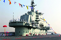 Military officers stand onboard Chinas aircraft carrier Liaoning in Dalian on Tuesday