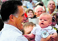 Republican presidential candidate Mitt Romney picks up a baby wearing a Dump Obama pin as he campaigns in Pueblo.