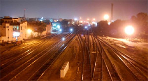 A view of the city at night from the Parasram Nagar overbridge with lights burning brightly near the railway tracks. 