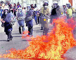 A molotov cocktail explodes in front of riot police officers near Syntagma square during a 24-hour labour strike in Athens on Wednesday