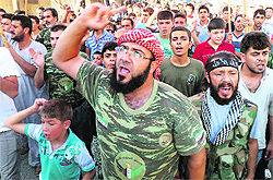 Members of the Free Syria Army and residents shout slogans during a protest against President Bashar al-Assad in Sermada near Idlib