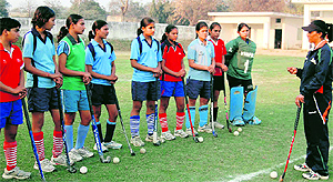 International hockey star Pritam Siwach gives tips to the trainees of Hockey Academy, Sonepat, during a practice session in Sonepat