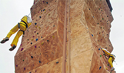 Students climb an artificial wall during a wall climbing competition held recently in Nowgam on the outskirts of Srinagar