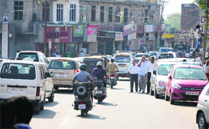 Haphazardly parked vehicles lead to a traffic jam on a busy city road in Jammu on Thursday. 