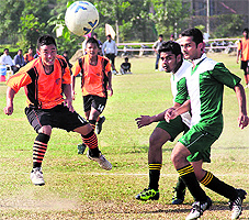 Players of LPU and IIT-Lucknow (in green T-shirt) kick the ball during the inaugural day of the North Zone Inter-University Football (Men) Championship held near Jalandhar on Thursday; and (right) the team of KMV Collegiate Senior Secondary School, Jalandhar, that has won the volleyball tournament in the Jalandhar District Inter-School Championship