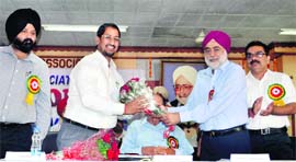Industrialist Onkar Singh Pahwa (right) presents a bouquet to Industry Minister Anil Joshi in Ludhiana on Thursday. 