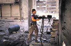 A rebel fighter uses a machine gun to fight government forces as they attempt to capture the Al-Arqub neighbourhood of Aleppo in Syria. 