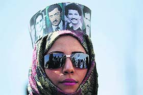 A protester wears a headband portraying disappeared political figures as part of The Walls Remember campaign to focus on forced disappearance of people in Sanaa, Yemen, on Thursday.
